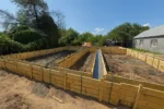 Строительство дома «Марк» 130 м² в посёлке Алатау, 2026: залитый ленточный фундамент в опалубке, общий вид площадки HotWell.kz