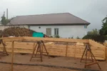 Строительство дома «Надежда» 100 м² в Павлодаре, 2026: по пятну застройки собрана деревянная опалубка ленточного фундамента, размечены внутренние ленты под несущие стены