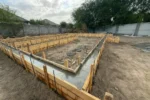 Дом «Сатурин» 165 м², Алматы, 2026: залит наружный контур ленточного фундамента, по верху лент выведена ровная бетонная поверхность, опалубка стянута шпильками и проволокой
