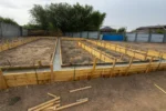 Дом «Сатурин» 165 м², Алматы, 2026: залиты наружные и внутренние ленты фундамента под несущие стены, бетон набирает прочность перед снятием опалубки