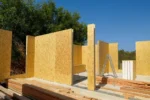 Дом «Сатурин» 165 м², Алматы, 2026: собранные стены комнат из СИП-панелей с дверными проёмами, на плите разложен пиломатериал под обвязку