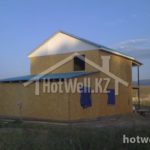 Проект дома «А-100ДД» из СИП-панелей, 100 м² — двухэтажный дом из сип-панелей с бирюзовой крышей на фоне гор | HotWell.KZ