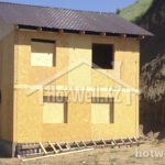 Проект дома «А-100ЗЗ» из СИП-панелей, 100 м² — двухэтажный дом с коричневой двускатной крышей на этапе стройки | HotWell.KZ