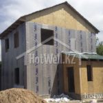 Проект дома «М-107» из СИП-панелей, 107 м² — двухэтажный дом на этапе утепления фасада с пристройкой | HotWell.KZ