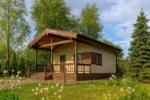 Проект бани «К-51» из СИП-панелей, 51 м² — одноэтажная баня с бежевым фасадом, коричневой крышей и крытым крыльцом | HotWell.KZ