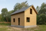 Дом «Б-102Б», 102 м², 1.5 этажа, в черновой отделке: коробка из СИП-панелей OSB-3, двускатная кровля из металлочерепицы, проёмы без окон и дверей, в проёмах видны сосновые балки перекрытия
