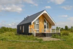 Проект дома «Б-104» из СИП-панелей, 104 м² — одноэтажный дом с черной крышей, деревянным фасадом и террасой | HotWell.KZ