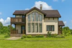 Проект дома «Б-220» из СИП-панелей, 220 м² — двухэтажный дом с бежевым фасадом, коричневой крышей и балконом | HotWell.KZ