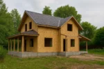 Дом «Ч-147», 147 м², 1.5 этажа, в черновой отделке: коробка из СИП-панелей OSB-3, двускатная кровля из металлочерепицы, проёмы без окон и дверей, в проёмах видны сосновые балки перекрытия