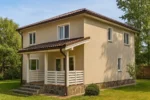 Проект дома «Е-180» из СИП-панелей, 180 м² — двухэтажный дом с бежевым фасадом, коричневой крышей и крытым крыльцом | HotWell.KZ