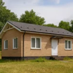 Проект дома «Е-70» из СИП-панелей, 70 м² — одноэтажный дом с бежевым фасадом, серой крышей и крытым крыльцом | HotWell.KZ