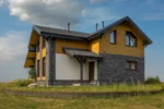 Проект дома «Г-182» из СИП-панелей, 182 м² — двухэтажный дом с серым фасадом, жёлтым сайдингом и серой крышей | HotWell.KZ