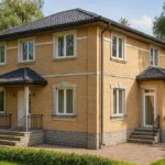 Проект дома «К-171Б» из СИП-панелей, 171 м² — двухэтажный дом с жёлтым фасадом, серой крышей и крыльцом | HotWell.KZ