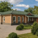 Проект дома «К-350» из СИП-панелей, 350 м² — одноэтажный дом с кирпичным фасадом, зелёной крышей и гаражом | HotWell.KZ