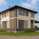 Проект дома «Л-162» из СИП-панелей, 162 м² — двухэтажный дом с коричневым кирпичным фасадом, черепичной крышей и террасой | HotWell.KZ