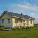 Проект дома «Н-100» из СИП-панелей, 100 м² — одноэтажный дом с жёлтым фасадом, серой крышей и крыльцом | HotWell.KZ