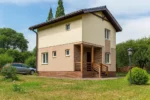 Проект дома «П-105» из СИП-панелей, 105 м² — двухэтажный дом с бежевым фасадом, коричневой крышей и крытым крыльцом | HotWell.KZ