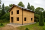 Дом «Р-152», 152 м², 2 этажа, в черновой отделке: коробка из СИП-панелей OSB-3, двускатная кровля из металлочерепицы, проёмы без окон и дверей, в проёмах видны сосновые балки перекрытия