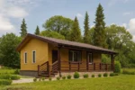 Проект дома «Р-54» из СИП-панелей, 54 м² — одноэтажный дом с жёлтым фасадом, коричневой крышей и террасой | HotWell.KZ