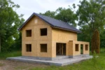 Дом «С-192Б», 192 м², 2 этажа, в черновой отделке: коробка из СИП-панелей OSB-3, двускатная кровля из металлочерепицы, проёмы без окон и дверей, в проёмах видны сосновые балки перекрытия