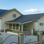 Проект дома «Т-311» из СИП-панелей, 311 м² — двухэтажный дом с бежевым фасадом, серой крышей и крытой террасой | HotWell.KZ