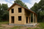 Дом «У-100Б», 100 м², 1.5 этажа, в черновой отделке: коробка из СИП-панелей OSB-3, двускатная кровля из металлочерепицы, проёмы без окон и дверей, в проёмах видны сосновые балки перекрытия