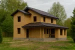 Дом «В-172», 172 м², 2 этажа, в черновой отделке: коробка из СИП-панелей OSB-3, двускатная кровля из металлочерепицы, проёмы без окон и дверей, в проёмах видны сосновые балки перекрытия