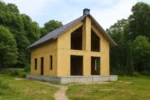Дом «В-185», 185 м², 1.5 этажа, в черновой отделке: коробка из СИП-панелей OSB-3, двускатная кровля из металлочерепицы, проёмы без окон и дверей, в проёмах видны сосновые балки перекрытия