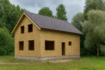 Дом «В-215», 215 м², 1.5 этажа, в черновой отделке: коробка из СИП-панелей OSB-3, двускатная кровля из металлочерепицы, проёмы без окон и дверей, в проёмах видны сосновые балки перекрытия