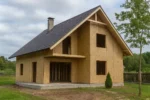 Дом «Ю-168», 168 м², 1.5 этажа, в черновой отделке: коробка из СИП-панелей OSB-3, двускатная кровля из металлочерепицы, проёмы без окон и дверей, в проёмах видны сосновые балки перекрытия
