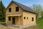 Дом «З-184», 184 м², 1.5 этажа, в черновой отделке: коробка из СИП-панелей OSB-3, двускатная кровля из металлочерепицы, проёмы без окон и дверей, в проёмах видны сосновые балки перекрытия