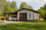 Проект гаража «Б-87Б» из СИП-панелей, 87 м² — одноэтажный дом с бежевым фасадом, коричневой крышей и навесом | HotWell.KZ