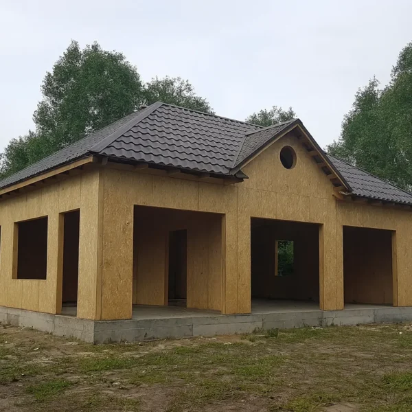 Дом «Г-143», 143 м², 1.5 этажа, в черновой отделке: коробка из СИП-панелей OSB-3, вальмовая кровля из металлочерепицы, проёмы без окон и дверей, в проёмах видны сосновые балки перекрытия