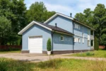 Проект гаража «М-41» из СИП-панелей, 41 м² — двухэтажный дом с синим фасадом, черной крышей и балконом | HotWell.KZ
