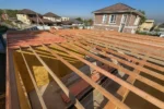 Дом «Сатурин» 165 м², Алматы, 2026: перекрытие сверху — балки уложены по всей площади дома, в проёме видна комната первого этажа